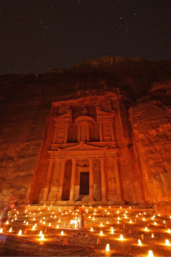 Picture of the Treasury during Petra at Night. It is lit up with a warm orange glow